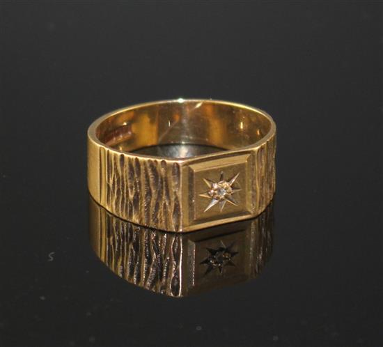 A modern 9ct gold and diamond chip set signet ring, with textured shoulders, size R/S, gross 3.9 grams.